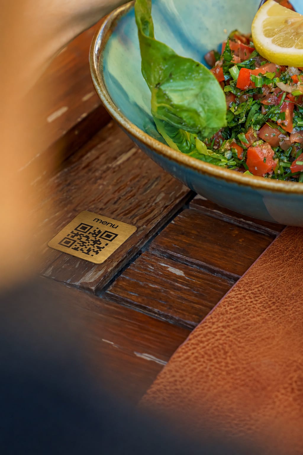 Une plaque QR code Swizee en métal posée sur une table de restaurant